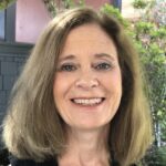 Heather Whelan, MD, smiles with a tree in the background.