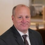 Head shot of Daniel S. Eiferman, MD, MBA, FACS wearing a suit jacket and tie.